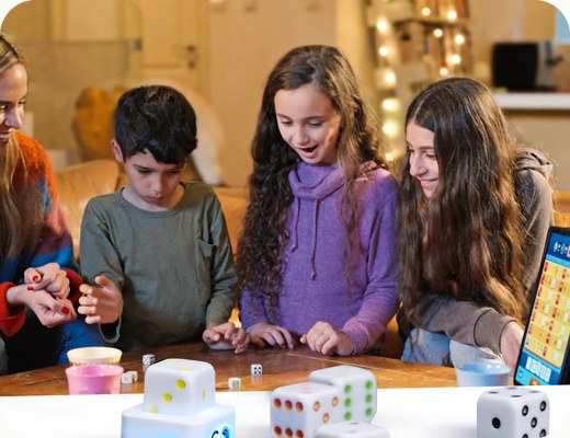 Two girls rolling GoDice at the table