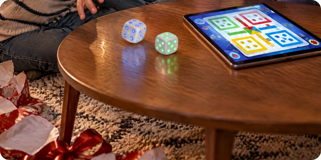 Kids throwing glowing GoDice next to a tablet game