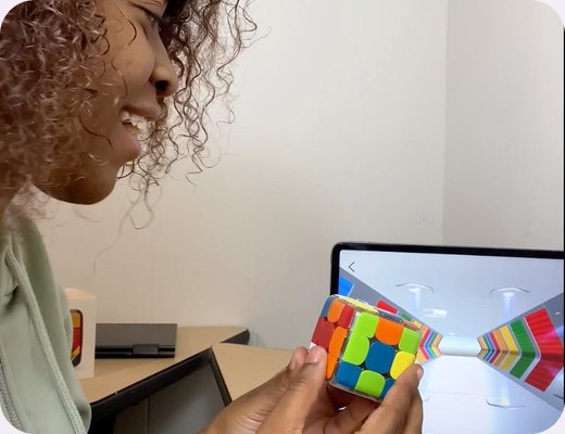 Hands solving GoCube next to a tablet